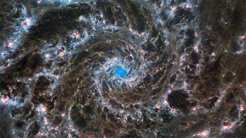 天文学家将哈勃太空望远镜和韦伯太空望远镜拍摄的M74星系的图片结合在一起后得出的M74星系图片