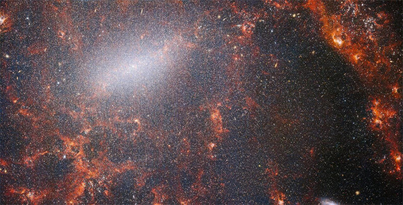 这张NGC 5068由韦伯太空望远镜NIRCam拍摄，此星系被大量的恒星群所包围，其中最密集的是沿着其明亮的中央棒状，以及被内部年轻恒星照亮的红色气体云。图片来源：图片来源：NASA / ESA / CSA / Webb / J. Lee / PHANGS-JWST Team